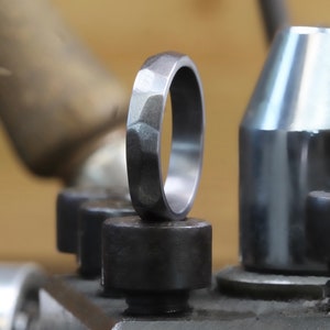 Fede nuziale sottile in tantalio. Anello in tantalio opaco con finitura martellata. Vestibilità comoda, forma leggermente a corte. INCISIONE GRATUITA.