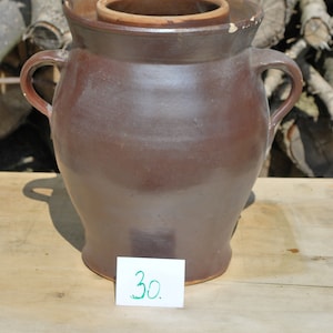 May include: A brown ceramic crock with two handles and a lid. The crock has a handwritten price tag that says "30."