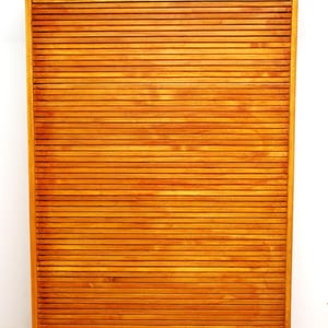 Könnte beinhalten: Ein hoher, rechteckiger Holzschrank mit einem Rollladen aus horizontalen Lamellen. Der Schrank hat eine hellbraune Oberfläche, zwei Metallgriffe oben an der Tür und ein zentrales Schlüsselloch am oberen Rahmen des Möbelstücks.