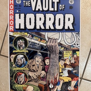 May include: Comic book cover for "The Vault of Horror" featuring a gruesome scene on a subway. The cover has the text "HORROR" in red and "THE VAULT OF HORROR" in white. The comic includes illustrations of The Vault-Keeper, The Crypt-Keeper, and The Old Witch.