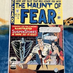 May include: A vintage comic book cover featuring a vampire in a coffin, a man holding a stake, and a woman looking scared. The cover is titled "The Haunt of Fear" and is from the "Illustrated SuspenStories" series. The comic book is number 16 and is from July-August.