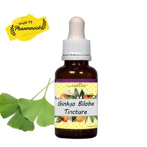 Puede incluir: Una botella de vidrio marrón de tintura de Ginkgo Biloba con un cuentagotas blanco. La etiqueta dice "Ginkgo Biloba Tincture" con un diseño floral. La imagen también incluye hojas verdes de Ginkgo y una pancarta amarilla que dice "made by Pharmacist".