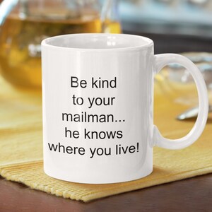 May include: White ceramic coffee mug with black text that reads "Be kind to your mailman... he knows where you live!"