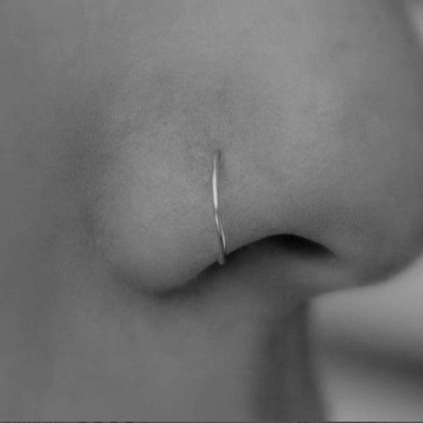 Discreto piercing en el aro de la nariz, piercing fino en el aro de la nariz