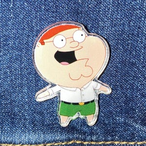 May include: A cartoon character with red hair, glasses, and a white shirt with green pants. The character is smiling with a wide open mouth.
