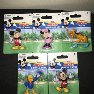 Peut inclure: Un ensemble de six figurines Disney Junior Mickey Mouse, chacune emball&eacute;e dans une plaquette en plastique. Les personnages incluent Mickey Mouse, Minnie Mouse, Pluto, Donald Duck et deux autres figurines Mickey Mouse. Chaque emballage pr&eacute;sente un fond color&eacute; avec une sc&egrave;ne de terrain de jeu et le nom du personnage.