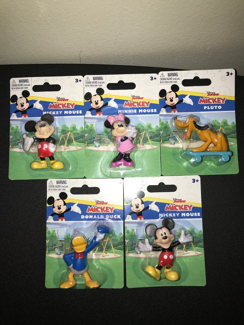 Peut inclure: Un ensemble de six figurines Disney Junior Mickey Mouse, chacune emball&eacute;e dans une plaquette en plastique. Les personnages incluent Mickey Mouse, Minnie Mouse, Pluto, Donald Duck et deux autres figurines Mickey Mouse. Chaque emballage pr&eacute;sente un fond color&eacute; avec une sc&egrave;ne de terrain de jeu et le nom du personnage.