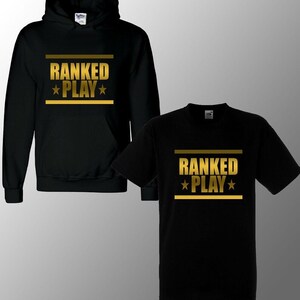 May include: Black hoodie and t-shirt with gold text that reads "RANKED PLAY" with a star on either side of the word "PLAY".