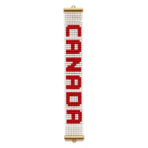 May include: A rectangular beaded bracelet featuring a white background with the word CANADA spelled out in red beads. The bracelet is finished with gold-toned metal end bars at the top and bottom, each featuring a small circular loop for attachment.
