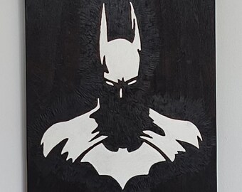 以下が含まれることがあります： 白黒のバットマンのシルエットアート作品。このアートワークは、バットマンの頭、フード、胸のエンブレムの白いアウトラインを持つテクスチャード加工の背景が特徴です。この画像は、スーパーヒーローの肖像画です。