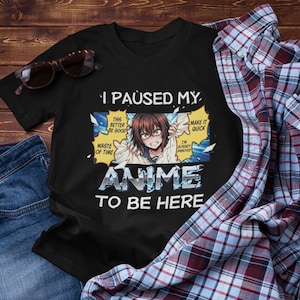 May include: Black t-shirt with the text "I PAUSED MY ANIME TO BE HERE" and a graphic of an anime character. The shirt is paired with blue jeans, a plaid shirt, and sunglasses.