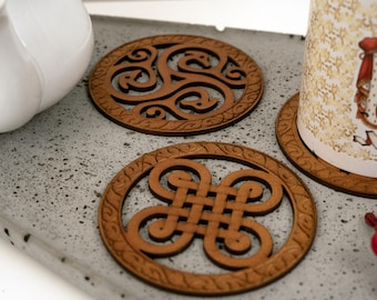 May include: Four wooden coasters with intricate Celtic knot designs. The coasters are round and have a brown wood finish.