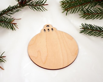 May include: A plain, unfinished wooden ornament shaped like a Christmas tree bauble. The ornament is ready to be painted or decorated.