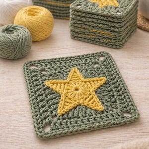 May include: Handmade crochet coasters in a stack, featuring a star design. The coasters are olive green with a yellow star in the center. Several balls of yarn in white, yellow, and green are also visible. The coasters are square and appear to be approximately 4 inches by 4 inches.