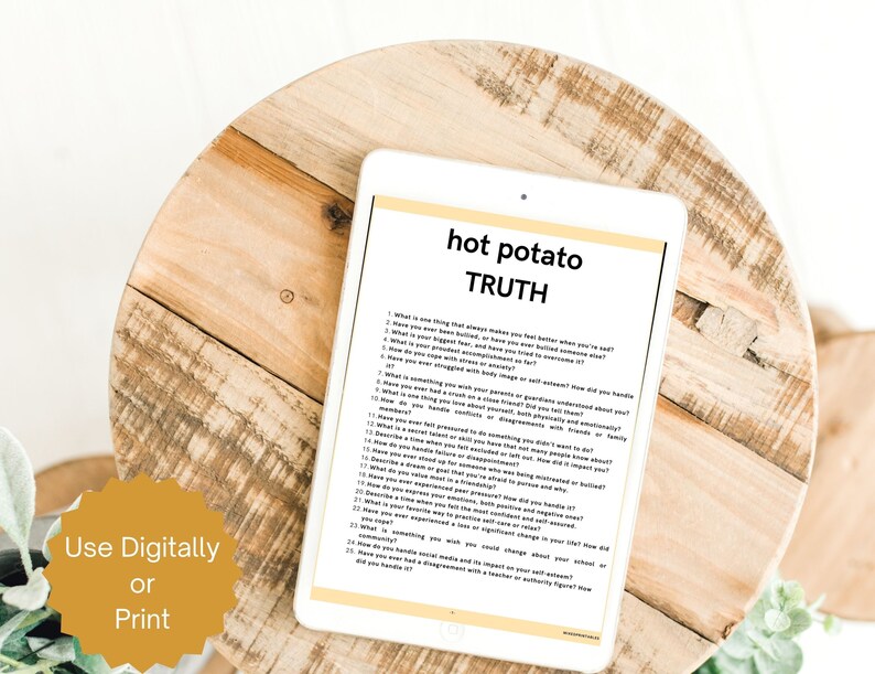 Puede incluir: Una tableta blanca muestra el texto "hot potato TRUTH" sobre una lista de preguntas. La tableta descansa sobre una superficie redonda de madera marr&oacute;n claro. Las palabras "Use Digitally or Print" est&aacute;n en un c&iacute;rculo amarillo.