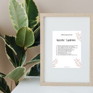 May include: A framed print with a light brown frame and a white background. The print features a list of affirmations for imposter syndrome with a floral design in a light pink color.