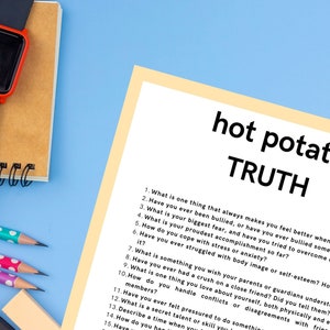 Puede incluir: Un fondo azul con un bloc de notas, l&aacute;pices y un reloj inteligente. Una hoja de papel con las palabras "hot potato TRUTH" y una lista de preguntas est&aacute; en el centro. El reloj tiene una pantalla negra y un marco rojo.