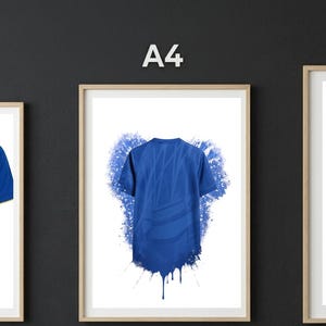 May include: Three framed prints labeled A5, A4, and A3. The A5 print shows a blue polo shirt with white piping. The A4 print displays a blue shirt with a watercolor splash effect. The A3 print features a blue shirt with a white paint drip design.