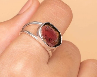 Könnte beinhalten: Ein Silberring mit einem großen, unregelmäßig geformten, rotbraunen Edelstein. Der Ring hat ein geteiltes Banddesign, wobei der Edelstein in einer Lünettenfassung gefasst ist. Der Edelstein hat ein natürliches, organisches Aussehen.
