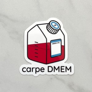 May include: A sticker featuring a cartoon-style container filled with red liquid. The container has a white body, a black cap with a blue circle, and the text "carpe DMEM" at the bottom. The label reads "DMEM (1X)".