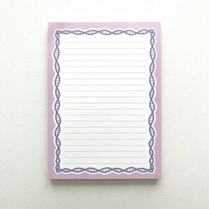 Peut inclure: Un bloc-notes rectangulaire avec une bordure violet clair et du papier ligné. La bordure présente un motif de brin d'ADN répétitif de couleur violet foncé. Le bloc-notes est conçu pour prendre des notes ou écrire des listes.