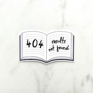 May include: A sticker featuring an open book design with the text "404 results not found" in black. The book has lined pages and a dark blue spine. The sticker is on a white background.