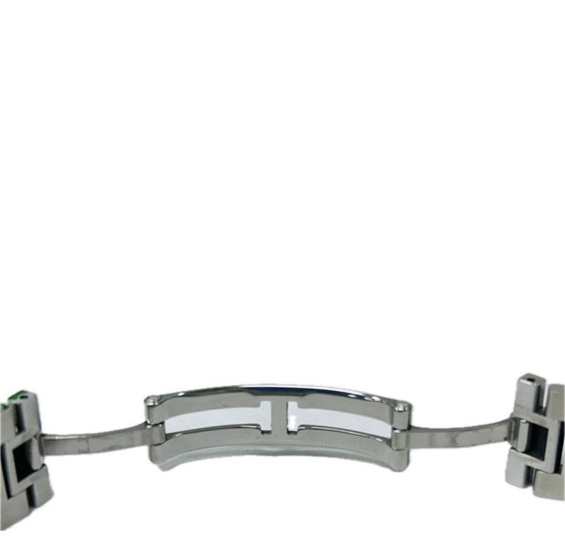 May include: A stainless steel watch clasp, featuring a polished finish. The clasp has a central hinge and two side attachments. The design is simple and modern, suitable for various watch styles.