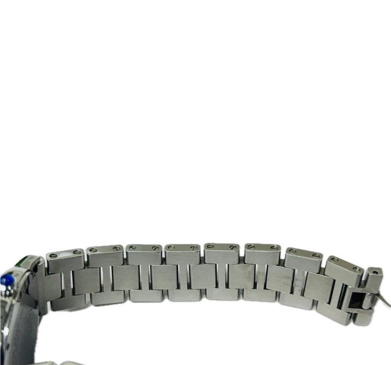 May include: Close-up of a silver-toned watch bracelet. The bracelet is composed of rectangular links, with a clasp visible at the end. The watch has a blue and green accent on the side.
