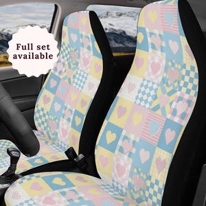 May include: A pair of car seat covers with a patchwork design featuring pink, yellow, and blue squares with hearts. The text "Full set available" is visible in the image.