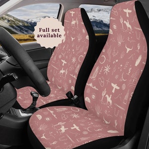 Op de afbeelding: Een paar autostoelhoezen met een roze achtergrond en een wit patroon van zuidwestelijk geïnspireerde ontwerpen, waaronder cactussen, bergen en sterren. De tekst "Full set available" is zichtbaar in een cirkel.