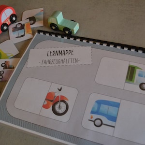Könnte beinhalten: Eine Lernkarte mit dem Titel "LERNMAPPE - FAHRZEUGHÄLFTEN -" und Bildern von Fahrzeugen, die in zwei Hälften geteilt sind. Die Bilder zeigen ein Motorrad, einen Bus, einen LKW und ein Auto.