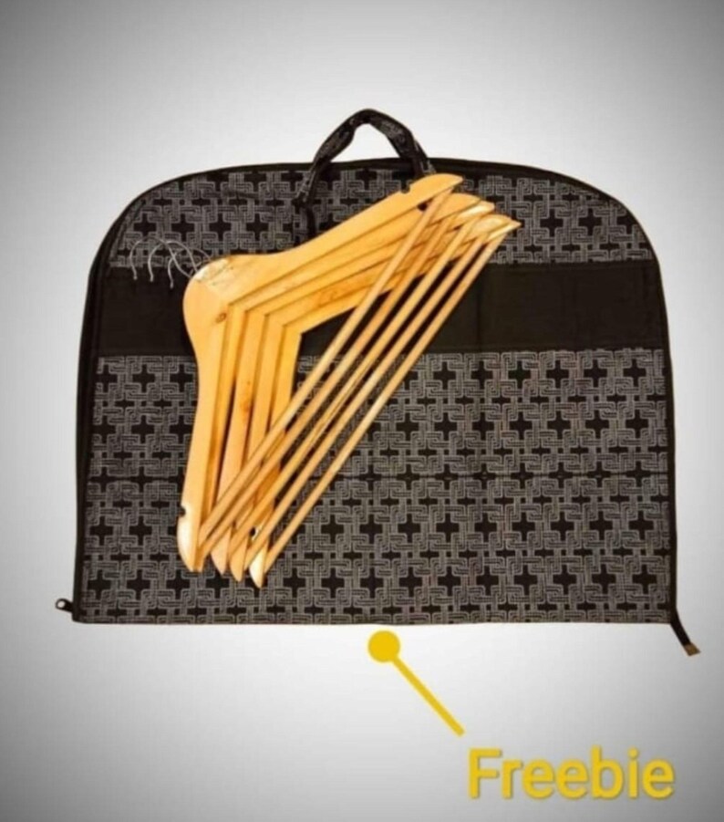 Op de afbeelding: Zwarte kledingtas met een wit geometrisch patroon en een ritssluiting. De tas is gevuld met houten hangers.