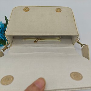 Handmade beaded handbag interior with ivory fabric lining and zip pocket compartment, artisan evening purse inside view showing magnetic snap closure and structured storage space, elegant beaded shoulder bag interior with secure zipper pocket for cards, cash or small essentials, luxury handcrafted evening handbag inside detail, bridal or wedding guest purse storage compartment, designer handmade beaded bag interior construction.