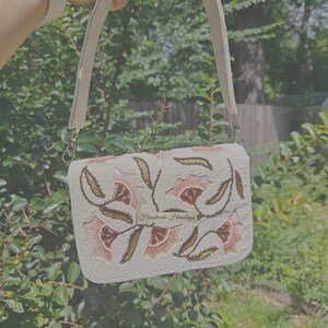 Peach floral beaded shoulder bag handmade with seed bead embroidery on ivory fabric, artisan handbag featuring peach flower and gold leaf beadwork pattern with structured top handle, elegant handmade beaded purse for wedding guest, spring party, bridal shower or formal event, romantic cottagecore floral handbag, luxury handcrafted evening bag, unique artisan beaded purse gift for her, statement embroidered floral shoulder bag, feminine spring fashion accessory.