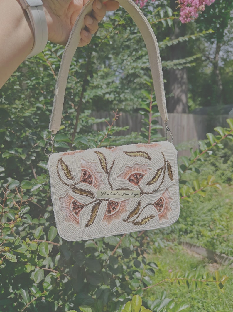 Peach floral beaded shoulder bag handmade with seed bead embroidery on ivory fabric, artisan handbag featuring peach flower and gold leaf beadwork pattern with structured top handle, elegant handmade beaded purse for wedding guest, spring party, bridal shower or formal event, romantic cottagecore floral handbag, luxury handcrafted evening bag, unique artisan beaded purse gift for her, statement embroidered floral shoulder bag, feminine spring fashion accessory.