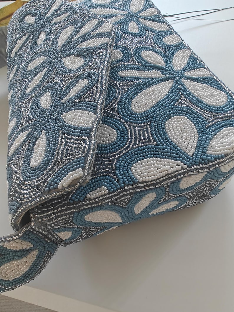 This side profile shot highlights the depth and structural integrity of the Chinoiserie style accessory, focusing on the reinforced gusset. The floral beaded bag maintains its shape even when empty, showcasing the professional tension of the hand-sewn beads. In terms of scale, the side view reveals a two-inch thickness, confirming it is a substantial party evening floral piece that offers more internal volume than a traditional flat envelope clutch.