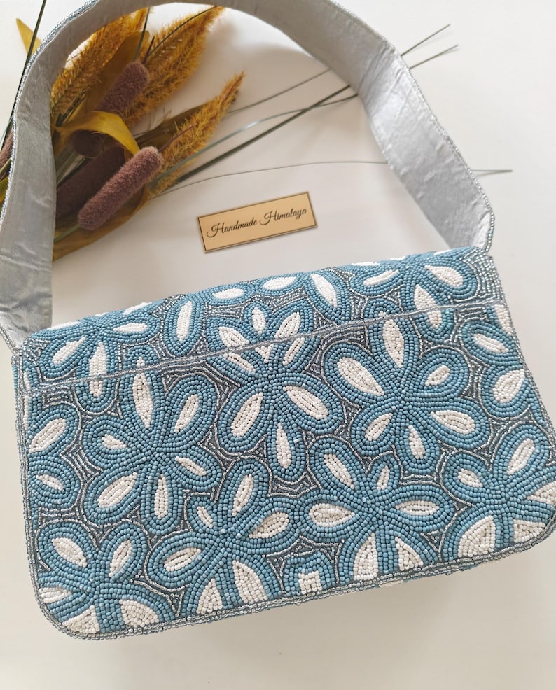 The back view of this Grandmillennial Bag demonstrates the continuous, uninterrupted seed bead wedding craftsmanship that wraps around the entire piece. The silver-grey beaded strap is shown attached at the sides, reinforcing its durability as a luxury beaded bag. To assist with visual search intent, the scale of the back panel is identical to the front, providing a sleek, snag-free surface that rests comfortably against a silk or lace dress.