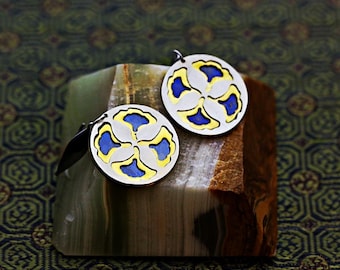 Round hoop earrings featuring a four-ginkgo-leaf motif in blue, gold brass and sleek silver.