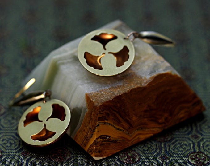 Round hoop earrings featuring a ginkgo leaf design in warm gold and yellow tones.