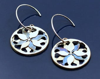 Blue and silver round hoop earrings adorned with a refined abstract floral motif.