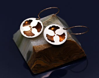 Round hoop earrings featuring a ginkgo leaf motif in vibrant orange and elegant silver.