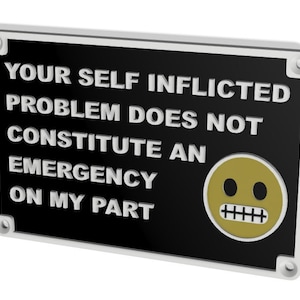 May include: Black sign with white text that reads "Your self inflicted problem does not constitute an emergency on my part". A yellow smiley face with a frown is on the right side of the sign.