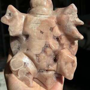 May include: A pink and white carved turtle figurine made of a natural stone with a unique, textured surface.