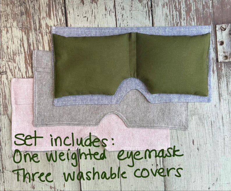 May include: A set of eye care products, including a green weighted eye mask and three washable covers in gray and pink. The text on the image reads: "Set includes: One weighted eye mask, Three washable covers."
