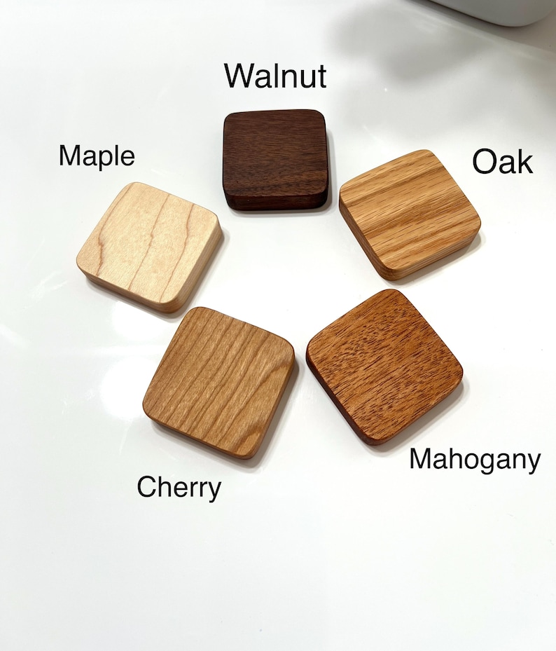 May include: Five square wooden samples arranged in a circle. The samples are labelled: Maple, Walnut, Oak, Cherry, and Mahogany. The wood grains vary in colour from light tan to dark brown. The text is in black, and the background is white.