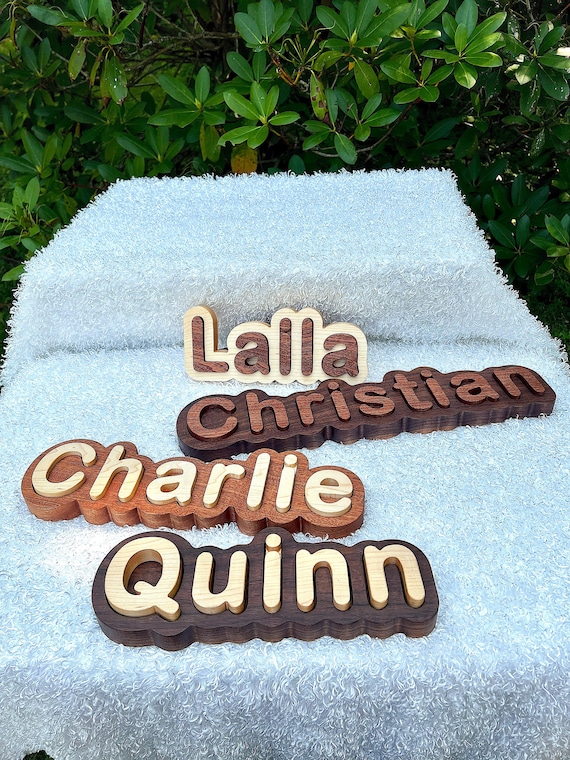 A natural hardwood name puzzle cut to the actual letters of a child's name — a Montessori-aligned toy that doubles as nursery décor and is genuinely handcrafted.