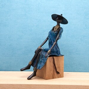 Woman wearing a hat and a blue dress in lost wax bronze