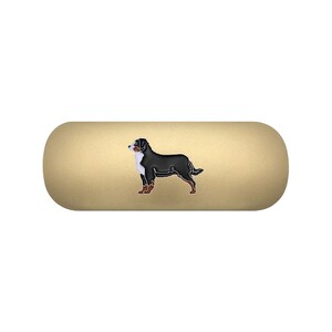 May include: A matte gold, pill-shaped hard case featuring a centred graphic illustration of a Bernese Mountain Dog. The dog is depicted in profile, showcasing its signature black, white, and rust-coloured coat against the solid gold background.