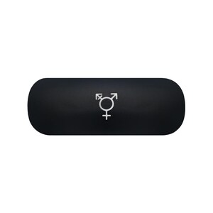 May include: A matte black, pill-shaped case featuring a centered, silver-colored transgender symbol. The object has rounded ends and a smooth, solid-colored surface, with the metallic icon clearly visible against the dark background.