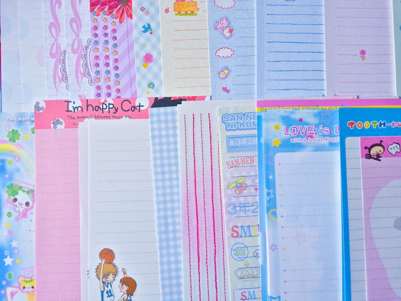 Puede incluir: Una colecci&oacute;n de hojas de papeler&iacute;a coloridas con varios dise&ntilde;os. Algunas hojas presentan papel rayado, mientras que otras tienen patrones decorativos como lazos, flores y personajes de dibujos animados. El texto "I'm happy Cat" y "LOVE is L" es visible.